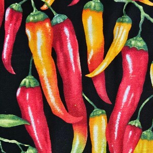 May include: A fabric pattern featuring a dense arrangement of chilli peppers in vibrant shades of red, orange, and yellow against a solid black background. Each pepper includes a green stem and exhibits a smooth, glossy texture with highlights.
