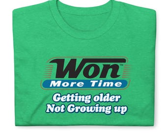 May include: A bright green short-sleeved t-shirt featuring a graphic design with the black text Won, the blue text More Time, and the white text Getting older Not Growing up, all centered on the front of the garment in a casual style.