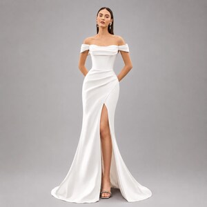 May include: A white off-the-shoulder wedding dress with a fitted bodice and a high slit. The dress has a flowing skirt that extends into a train. The model is wearing silver heels.