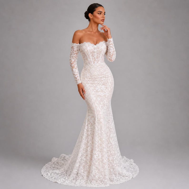 May include: A white lace wedding dress with an off-the-shoulder design and long sleeves. The gown has a fitted bodice and a mermaid skirt that flares out from the knees. The dress features a sweetheart neckline and a train.