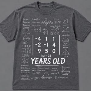 May include: A charcoal gray short-sleeve t-shirt featuring a white graphic print of various mathematical formulas, geometric shapes, and a central matrix calculation. The text "YEARS OLD" is printed in large white letters below the matrix.
