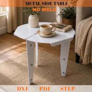May include: White metal side table with a unique, no-weld design. The table has a round top with a split design and three legs. The table is holding a cup of coffee, a saucer, a book, and a vase. The text "METAL SIDE TABLE NO WELD" is at the top.