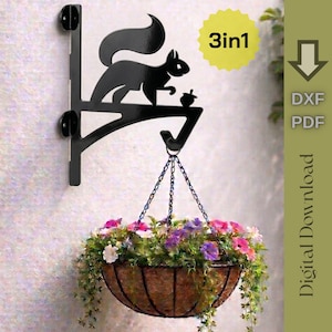 May include: A black metal wall bracket featuring a squirrel silhouette with an acorn, supporting a hanging planter filled with colourful flowers. The image includes text stating 3in1, DXF, PDF, and Digital Download with a downward arrow icon.