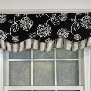 May include: Black and white valance with a scalloped edge and a floral pattern. The valance is made of fabric and has a striped bottom border.