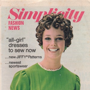 Könnte beinhalten: Ein Titelbild des Magazins Simplicity Fashion News mit einer Frau mit lockigem Haar, die ein grünes Kleid mit weißer Spitzenborte trägt. Der Text auf dem Titel lautet "all-girl" dresses to sew now...new JIFFY® Patterns...newest sportswear. Das Titelbild zeigt auch den Text "FEATURING MAY PATTERNS".