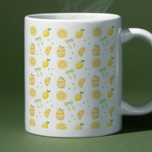 Pode incluir: Uma caneca de cerâmica branca com um padrão repetitivo de limões amarelos, fatias de limão e pequenos laços verde-claros. A caneca tem uma alça curva no lado direito e emite um fino rastro de vapor, indicando uma bebida quente no interior.