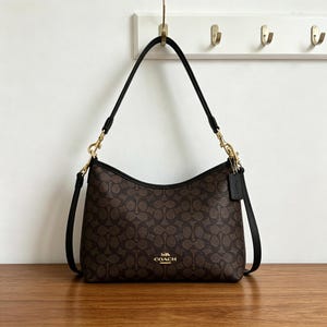Coach's classic monogrammed shoulder bag, featuring gold-tone hardware, is the perfect everyday work bag for women.