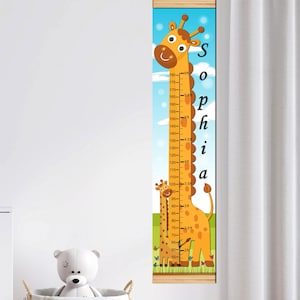 May include: A vertical hanging growth chart featuring a cartoon giraffe illustration against a blue sky and green grass background. The chart displays measurements in both centimeters and feet, with the name Sophia printed vertically in black.