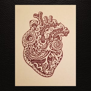 May include: A detailed illustration of a human heart, rendered in a deep reddish-brown hue. The heart is filled with intricate patterns and swirls, resembling a henna design. The artwork is set against a cream-colored background.