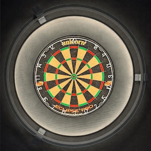 May include: A circular dartboard with a black background, featuring red, green, and yellow segments. The board has a central bullseye and is surrounded by a gray ring with the text "Unicorn" and "Eclipse Pro 2".