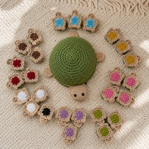 May include: A large central crocheted turtle with a green shell and tan head, surrounded by numerous smaller crocheted turtle appliques in various colors including blue, brown, red, white, black, yellow, pink, purple, and green.