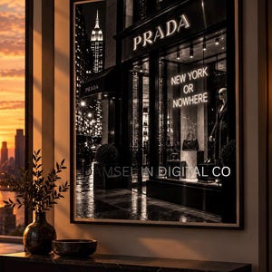 May include: A framed wall art print depicting a black and white night scene of a Prada storefront in New York City. The storefront window displays the text NEW YORK OR NOWHERE in neon lettering, a handbag, and a mannequin. The Empire State Building is visible.