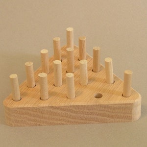 May include: A wooden triangular game board with 15 holes and 15 wooden pegs. The pegs are arranged in a triangular pattern.