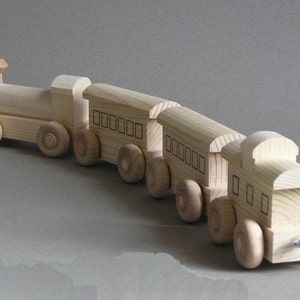 May include: A wooden toy train set with a locomotive and three cars. The train is made of natural wood and has a simple design. The cars have windows and are connected to each other by metal couplers.
