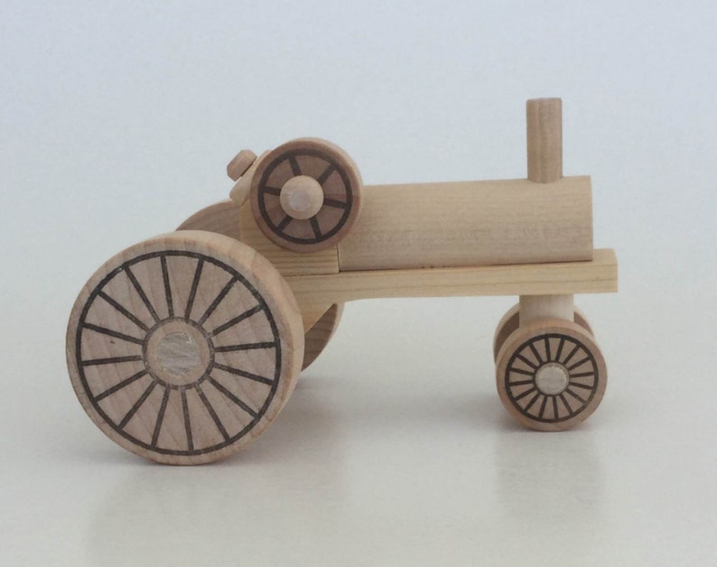 K&ouml;nnte beinhalten: Ein h&ouml;lzerner Spielzeugtraktor mit braunem Design auf den R&auml;dern. Der Traktor hat einen einzelnen, hohen Auspuff.