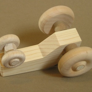 Op de afbeelding: Een houten speelgoedauto met vier wielen. De auto is gemaakt van onbehandeld hout en heeft een eenvoudig ontwerp. De auto is een geweldig speelgoed voor kinderen van alle leeftijden.