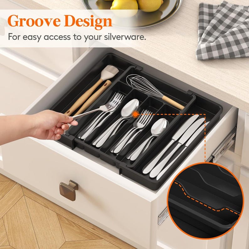 May include: A black silverware organizer with multiple compartments, holding forks, spoons, knives, and kitchen utensils. The text "Groove Design" and "For easy access to your silverware" are visible.