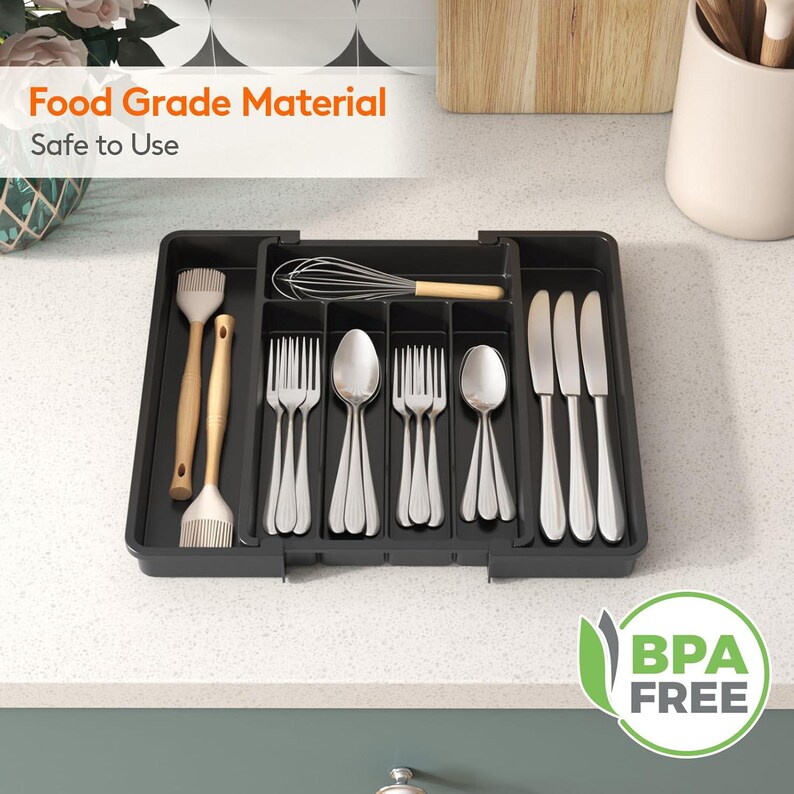 May include: A black plastic utensil organizer with compartments holding silverware, a whisk, and cooking brushes. The text "Food Grade Material Safe to Use" and "BPA FREE" are visible.