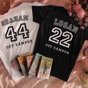 May include: Two short-sleeved t-shirts, one white and one black, with collegiate-style lettering. The white shirt has "GRAHAM 44 OFF CAMPUS" printed on it. The black shirt has "LOGAN 22 OFF CAMPUS". Several books are also visible.