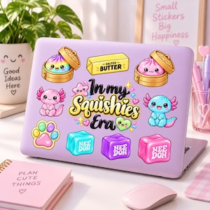 May include: A light purple laptop lid decorated with various colorful stickers including two dim sum baskets with cute faces, a stick of salted butter, a pink axolotl, a blue axolotl, a paw print, and three cubes labeled Nee Doh with the text In my Squishies Era.