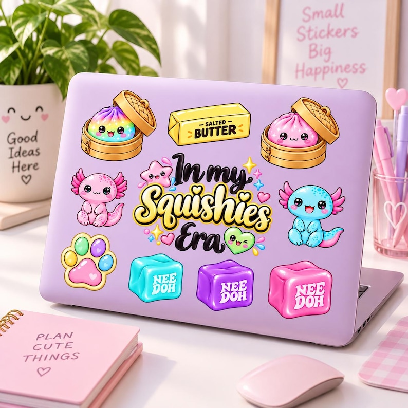 May include: A light purple laptop lid decorated with various colorful stickers including two dim sum baskets with cute faces, a stick of salted butter, a pink axolotl, a blue axolotl, a paw print, and three cubes labeled Nee Doh with the text In my Squishies Era.