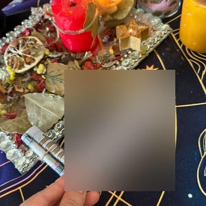 Puede incluir: Una colecci&oacute;n de art&iacute;culos espirituales, que incluye velas encendidas en tonos rojo, amarillo y verde, dispuestas sobre una bandeja decorativa. La bandeja est&aacute; adornada con flores y hojas secas. Tambi&eacute;n se ve un peque&ntilde;o frasco de vidrio con gr&aacute;nulos rosas y una vela dorada.