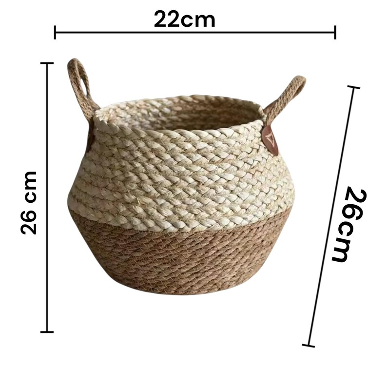 May include: A round woven basket featuring a two-tone design with a light cream upper section and a natural tan lower section. The basket includes two side handles with brown accents. Dimensions are 8.66 inches in width and 10.24 inches in height.