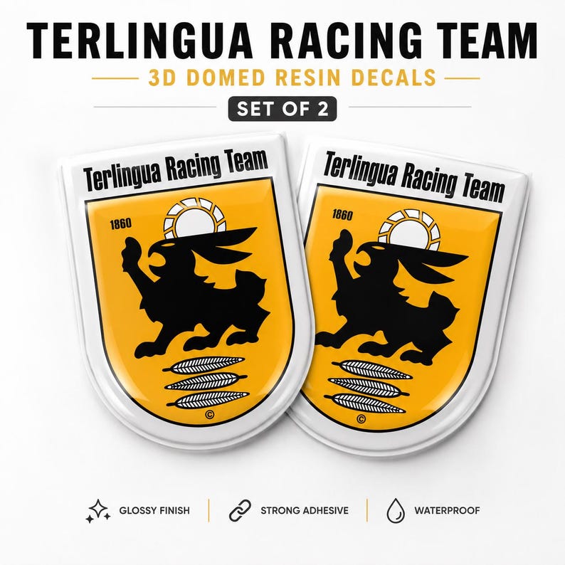 May include: A set of two Terlingua Racing Team 3D domed resin decals. Each shield-shaped decal features a yellow background with a black rabbit graphic, the text Terlingua Racing Team, the year 1860, a sun icon, and three feathers above a copyright symbol.
