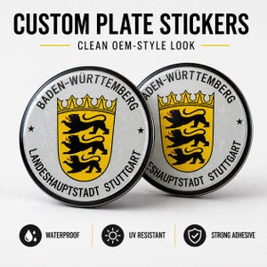 Könnte beinhalten: Zwei runde, individuelle Kennzeichenaufkleber mit dem Text "CUSTOM PLATE STICKERS" und "CLEAN OEM-STYLE LOOK". Jeder Aufkleber zeigt das Wappen von Baden-Württemberg mit einem gelben Schild und schwarzen Löwen. Die Aufkleber sind wasserfest, UV-beständig und haben einen starken Klebstoff.