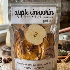 May include: A clear, resealable pouch containing a simmer pot kit labeled apple cinnamin. The contents include freeze-dried apple slices, dried orange slices, cinnamon sticks, whole star anise, and whole cloves. The label lists the ingredients.