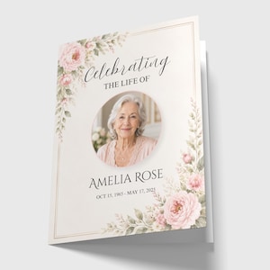 Op de afbeelding: Een herdenkingskaart met een portret van Amelia Rose, omlijst door een bloemenontwerp met roze rozen en groene bladeren. De tekst luidt "Celebrating the Life of Amelia Rose, Oct 15, 1965 - May 17, 2025."