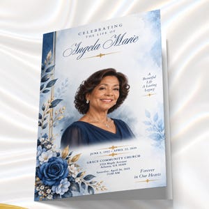 May include: A funeral program featuring a portrait of a woman in a navy blue dress. The design includes blue watercolor accents, gold lines, and blue roses. Text reads: Celebrating the Life of Angela Marie, June 5, 1952 - April 22, 2025, Grace Community Church.