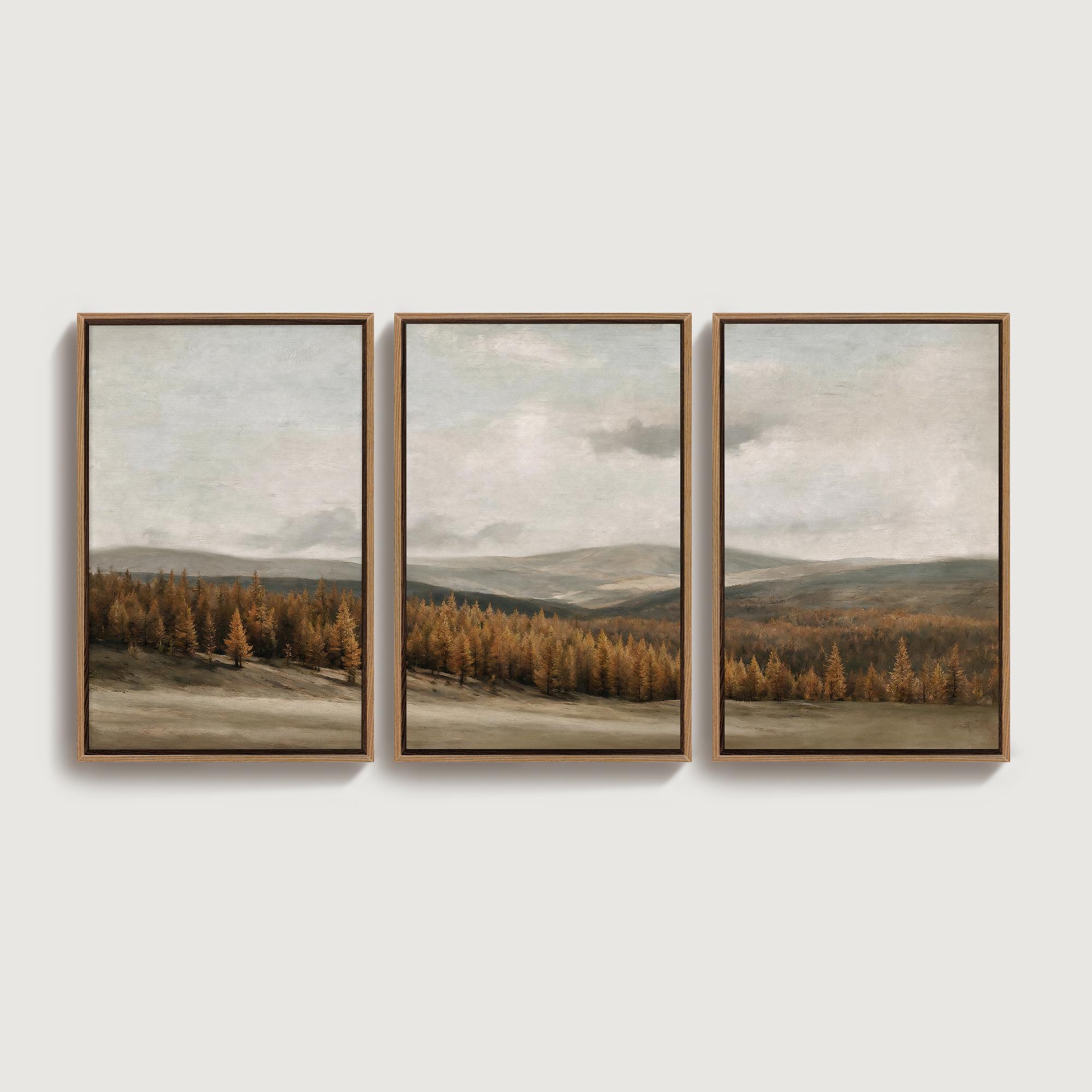 May include: A triptych of three framed landscape prints featuring a panoramic view of a golden-brown forest at the base of rolling hills under a cloudy, muted sky. Each rectangular print is encased in a thin, dark brown wooden frame.