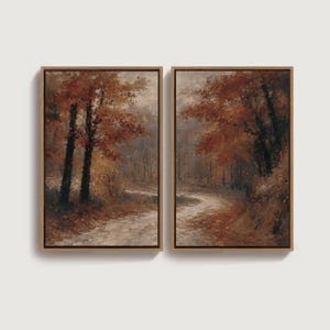 May include: A set of two rectangular framed wall art prints featuring an oil painting style landscape of a forest path during autumn. The scene depicts dark tree trunks, rust-colored foliage, and a winding dirt road in a muted, earthy color palette.