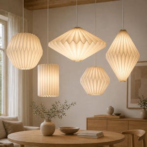 Puede incluir: Colección de cinco lámparas colgantes con pantallas geométricas plisadas de color claro. Las pantallas, suspendidas del techo, presentan formas como una esfera, un rombo, un cilindro, un hexágono y un cuadrado. Iluminación interior moderna.