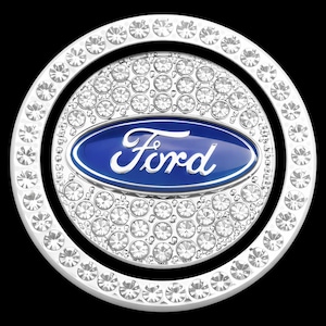 May include: A silver and crystal Ford emblem with a blue oval center. The emblem is surrounded by a ring of crystals and a second ring of crystals. The word "Ford" is written in white script.