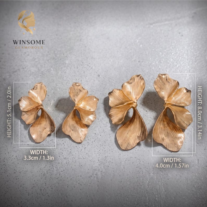 May include: Two pairs of gold-toned metal earrings shaped like ginkgo leaves with textured surfaces. The smaller pair measures 2.0 inches in height and 1.3 inches in width. The larger pair measures 3.14 inches in height and 1.57 inches in width.