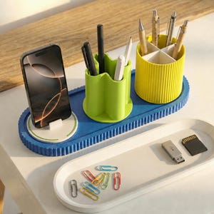Pode incluir: Um conjunto moderno de organizador de mesa em tons de azul, verde e amarelo. O conjunto inclui um suporte para telefone, porta-canetas e uma bandeja para pequenos objetos. O organizador foi projetado para manter um espaço de trabalho arrumado.