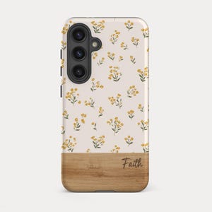 May include: A rectangular phone case featuring a light cream background with a repeating pattern of small yellow flowers and green leaves. The bottom section of the case has a wood grain texture with the name Faith printed in a dark brown script font.