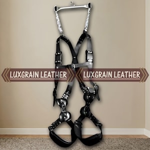 May include: Black leather harness with silver-toned metal accents. The harness features adjustable straps, buckles, and a connecting bar at the top. The text "LUXGRAIN LEATHER" is displayed on the image.