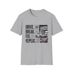 May include: A gray t-shirt with a graphic that reads "DRIVE. BREAK. FIX. REPEAT." The graphic includes a car, garage, and tools. The shirt is a crew neck and has short sleeves.