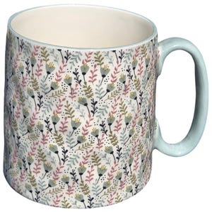 May include: A ceramic mug with a light blue handle and a cream-colored interior. The exterior features a repeating pattern of small stylized flowers and leafy sprigs in muted shades of sage green, dusty pink, and dark gray on a white background.