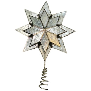 May include: A multi-pointed star tree topper constructed from iridescent, pearlescent glass panels held together by thin metal solder lines. The star features a layered, geometric design and is attached to a coiled metal wire base for mounting.