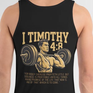May include: Black tank top featuring a weightlifter graphic with the text "I Timothy 4:8". The graphic includes a weightlifter lifting a barbell. The text below reads "For bodily exercise profiteth little..."