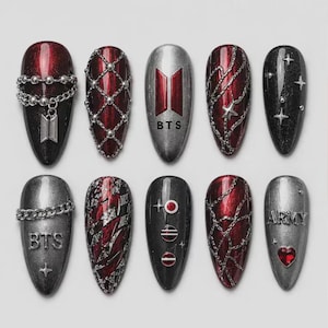 May include: A set of ten almond-shaped press-on nails featuring a dark red and silver color palette. Designs include metallic chains, a BTS logo, star accents, a red heart gem, and the word ARMY in silver lettering against a dark metallic finish.