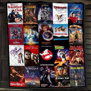 Peut inclure: Une courtepointe rectangulaire présentant une grille de vingt affiches de films classiques des années 1980, dont The Breakfast Club, The Goonies, Beetlejuice, Gremlins, Flight of the Navigator, The Neverending Story, Labyrinth, Stand By Me, Big Trouble in Little China, Dirty Dancing, The Lost Boys, Ghostbusters, Back to the Future, The Last Dragon, Bloodsport, Short Circuit, RoboCop, The Karate Kid et Highlander.