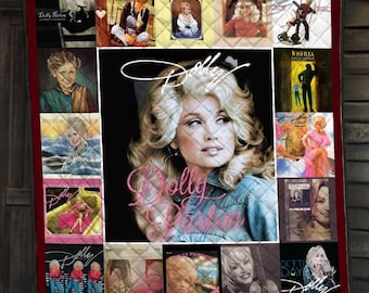 May include: A rectangular quilted throw blanket featuring a large central portrait of Dolly Parton with her name in script, surrounded by a collage of various album covers and promotional photographs of the artist, all framed by a dark red border.