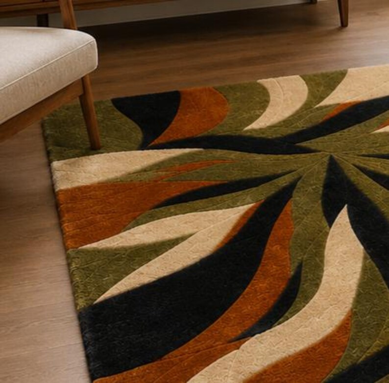 May include: A rectangular area rug featuring a large-scale, swirling abstract pattern. The design consists of curved, organic shapes in deep olive green, burnt orange, black, and cream, with a textured, tufted pile surface throughout the rug.