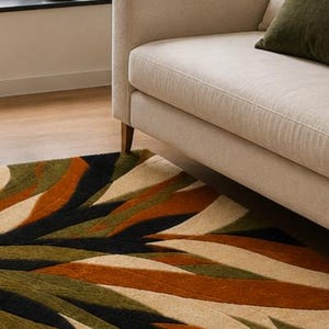 May include: A rectangular area rug featuring a bold, abstract pattern of sweeping, curved bands in shades of olive green, burnt orange, black, and cream. The design creates a dynamic, layered effect across the surface of the floor covering.
