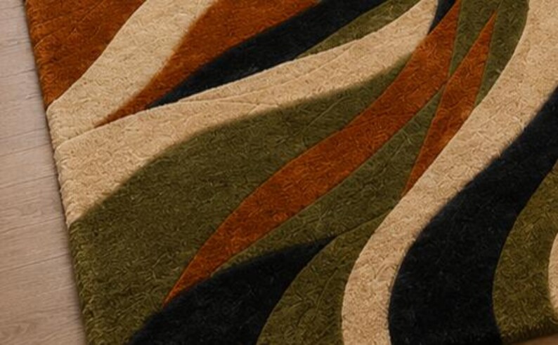 May include: A rectangular area rug featuring a textured, multi-colored pattern of sweeping, curved bands in shades of deep rust orange, olive green, black, and light beige. The surface has a carved, dimensional pile with varying heights.